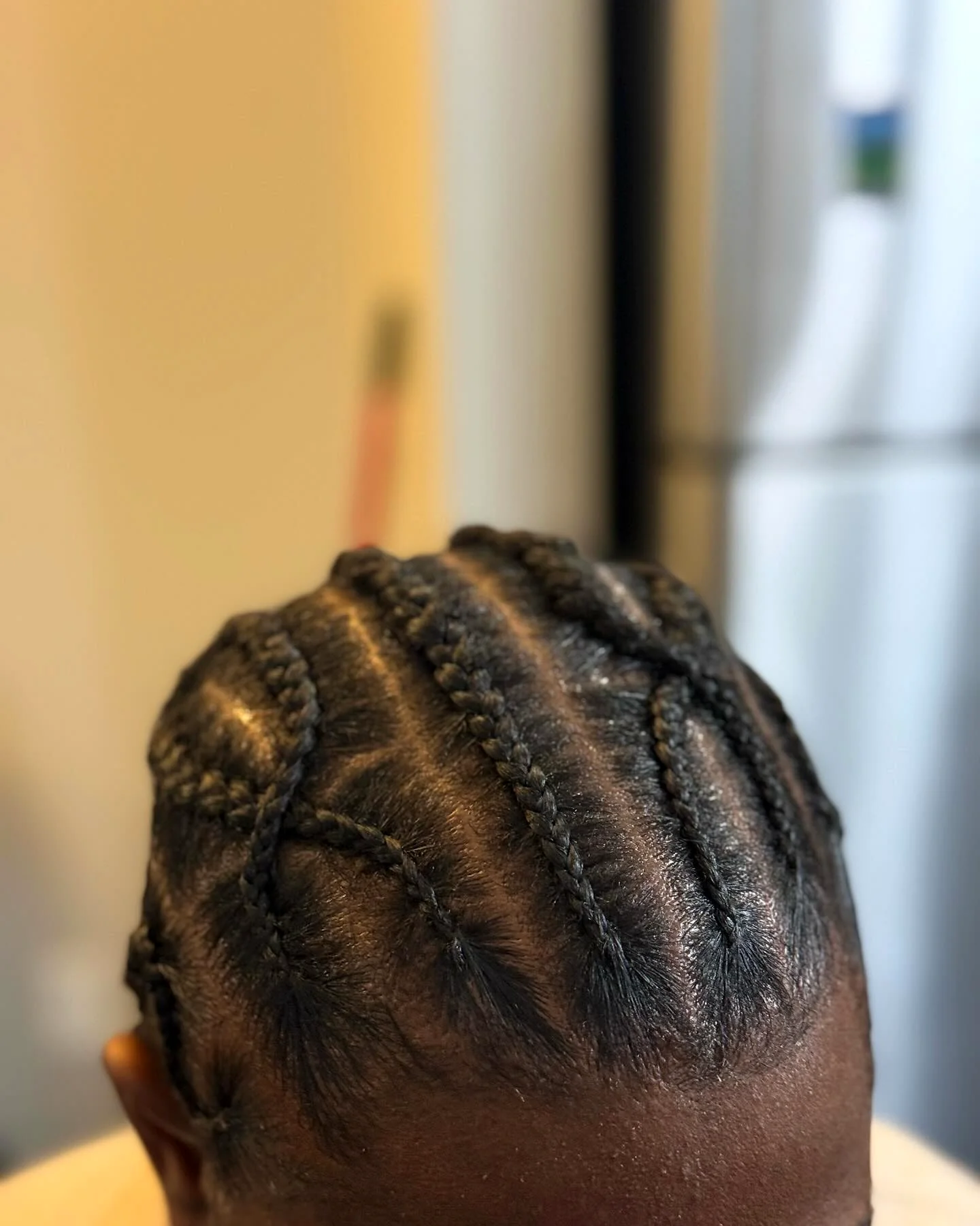 Close-up of cornrows braided in curved lines toward the back of the head