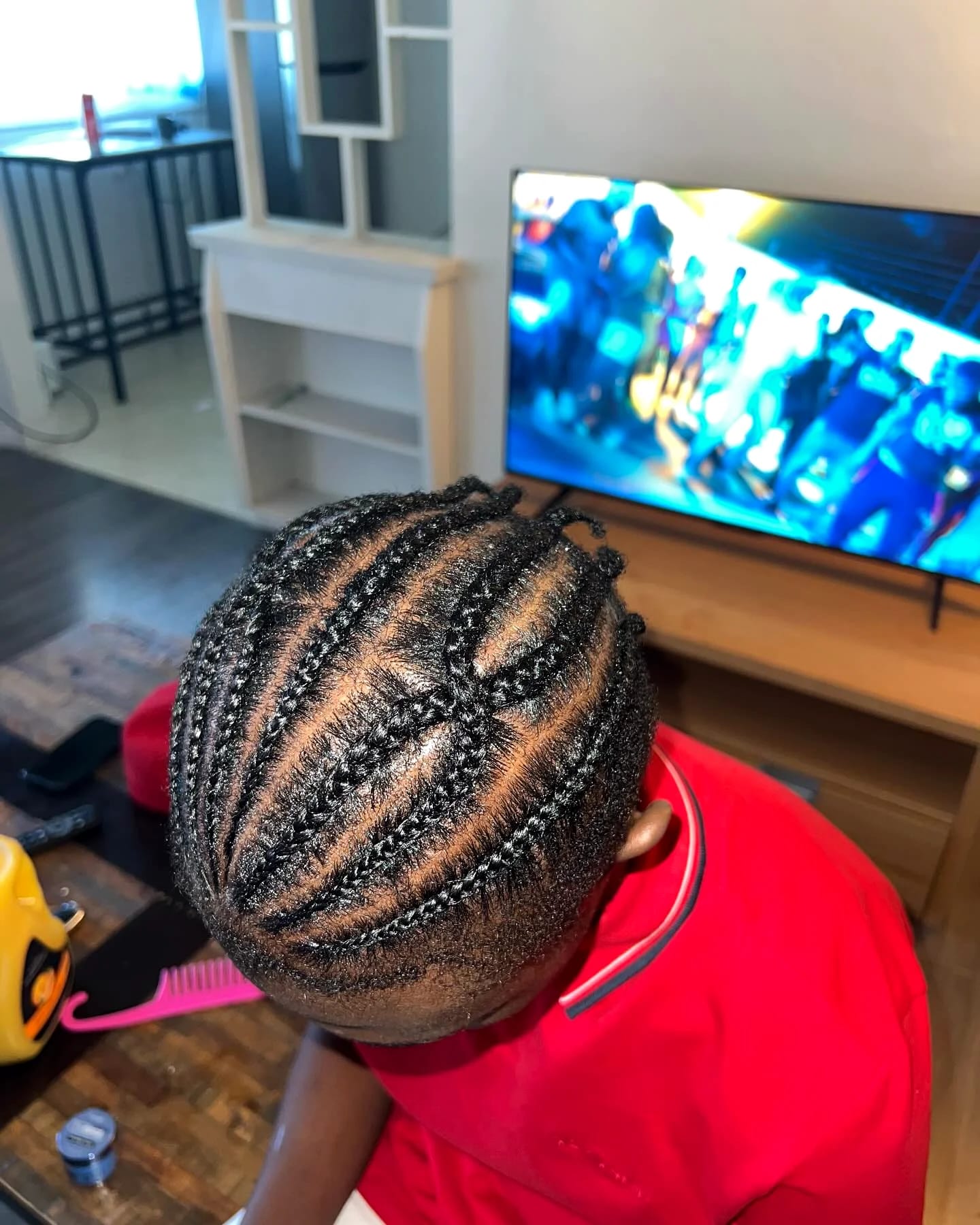 Close-up of patterned cornrows with crossing parts, viewed from above